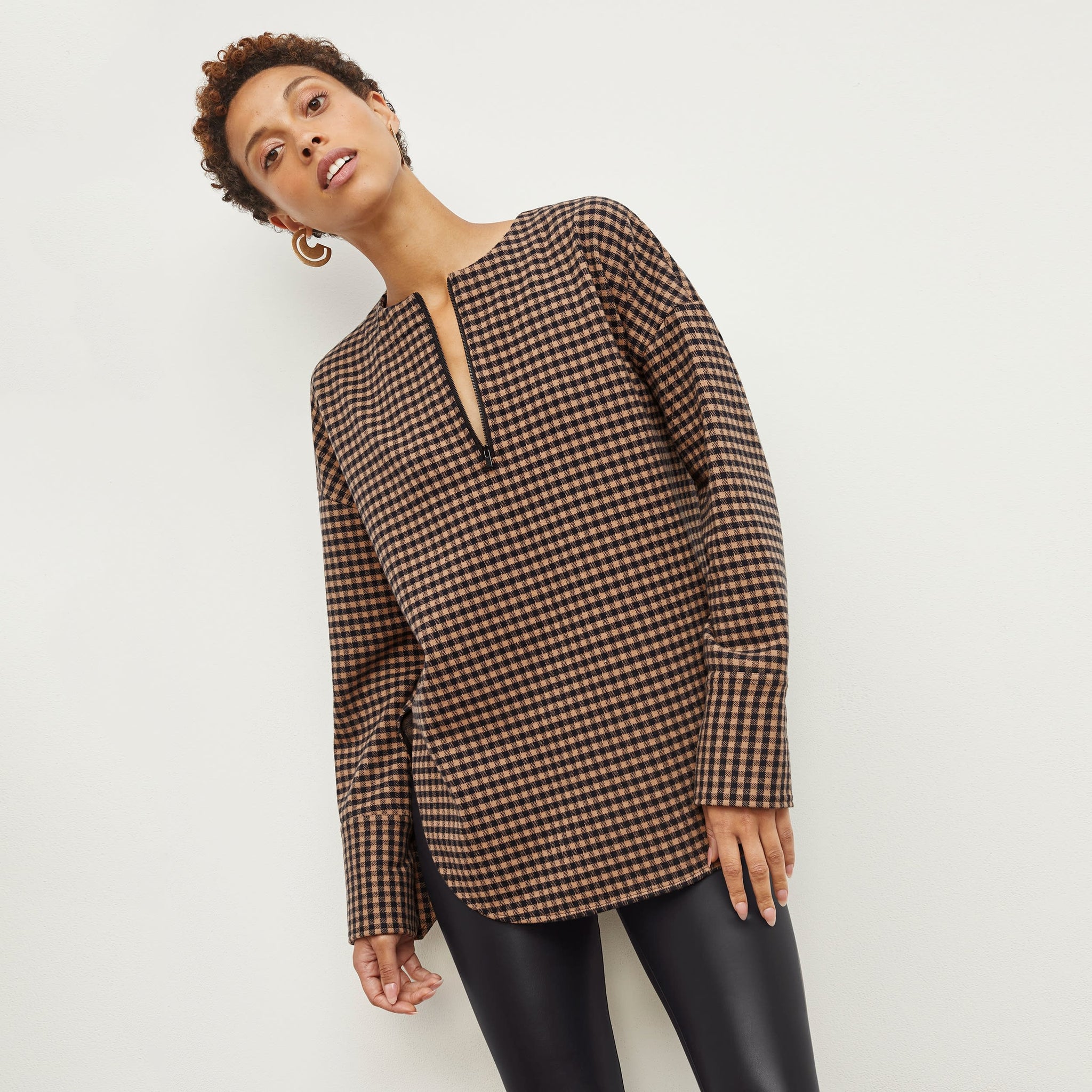 Front image of a woman standing wearing the Tully Top—Plaid Knit in Camel / Black