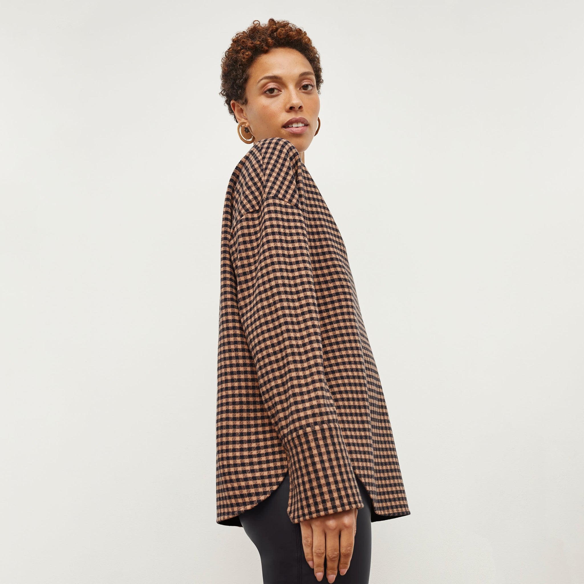 Side image of a woman standing wearing the Tully Top—Plaid Knit in Camel / Black